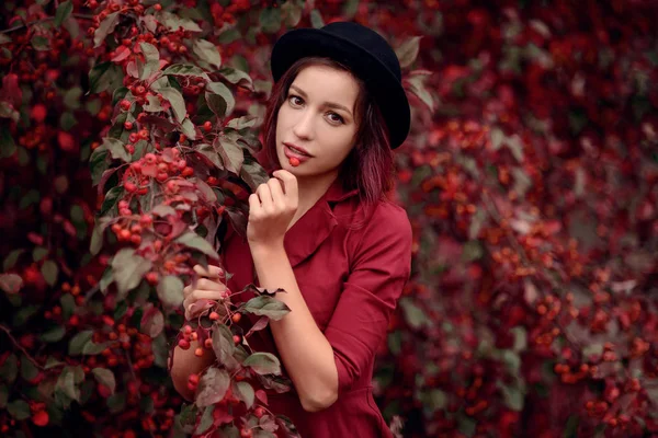 모자와 나무와 포즈를 취하는 빨간색 셔츠에 머리를 여자의 야외가 — 스톡 사진