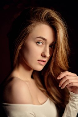 Beyaz bluz Studio doğal ışık ile poz uzun esmer hantal saçlı güzel kadın moda fotoğrafı