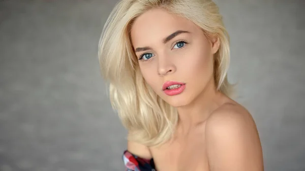 Vacker kvinna med blont hår med röda läppar poserar på lig — Stockfoto