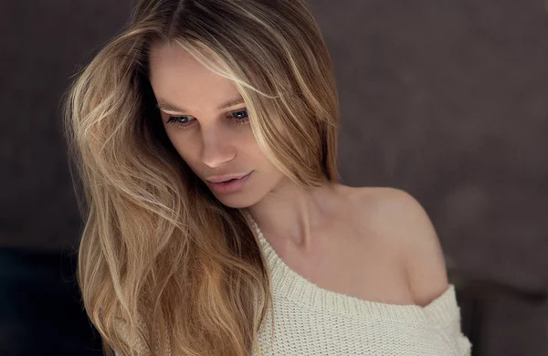 Belle femme avec de longs cheveux blonds en pull tricoté posant — Photo