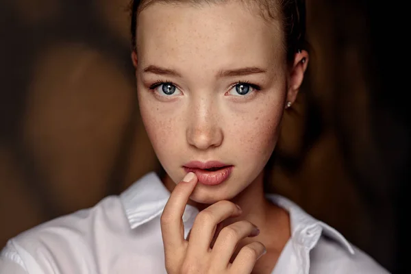 Schöne Frau mit brünetten Haaren und blauen Augen im weißen Hemd — Stockfoto