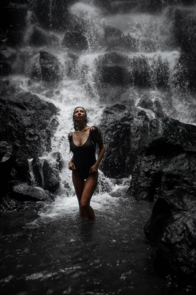 Belle femme aux cheveux bruns en maillot de bain noir posant sur — Photo