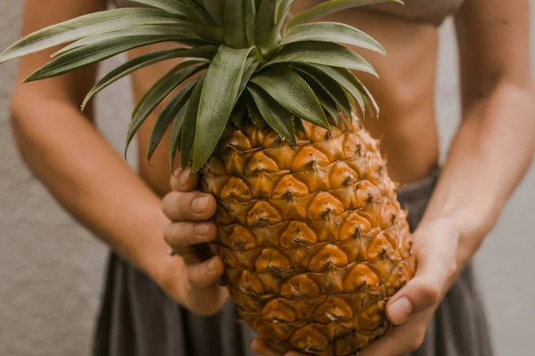 Mulher em roupas boho manter o abacaxi fruta tropical em mãos — Fotografia de Stock