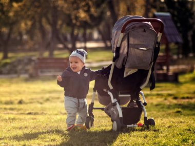 küçük mutlu bebek çocuk rahat kıyafetler ile onun gri sto yürüyüş içinde