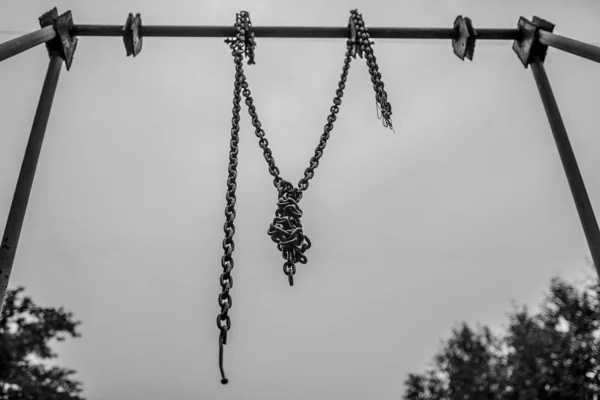 Single chain on the swing on the dark background — Stock Photo, Image