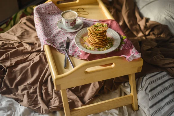 tasty breakfast in bed from eastern pancakes and Masala tea, ser
