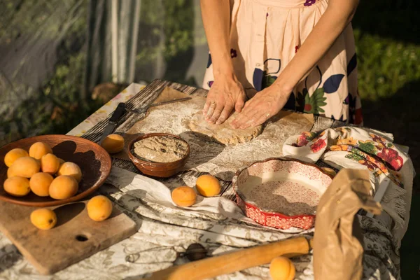 Mujer en suave vestido de sol cocinar un pastel dulce con albaricoques frescos —  Fotos de Stock