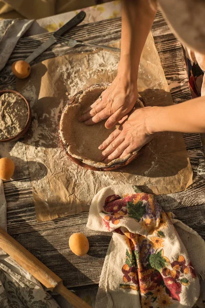 Frau in sanfter Kleidung kocht süße Torte mit frischen Aprikosen — Stockfoto