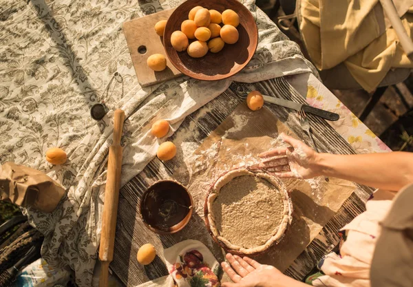 Mulher em vestido de verão doce cozinhar uma torta doce com damascos frescos — Fotografia de Stock
