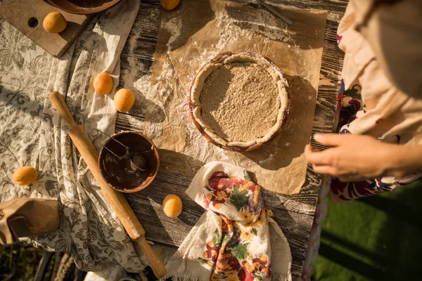 Mulher em vestido de verão doce cozinhar uma torta doce com damascos frescos — Fotografia de Stock