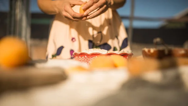 woman in gentle sundress cooking a sweet pie with fresh apricots