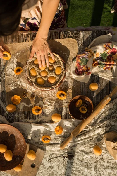 Mujer en suave vestido de sol cocinar un pastel dulce con albaricoques frescos —  Fotos de Stock