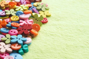 Açık yeşil renk Peluş kumaş üzerinde farklı şekiller, renk ve boyutlarda birçok düğmeler. Kopyalama alanı