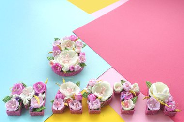 Yazıt Mart 8 renkli kağıttan yapılmış soyut bir arka plan üzerinde Rus harfleri pastel tonları çok renkli çiçekler ile kaplıdır. kopyalama alanı.
