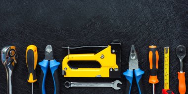 Yapım ve onarım için el aletleri seti, siyah doku arka planına düzgünce yerleştirilmiş. Boşluğu kopyala