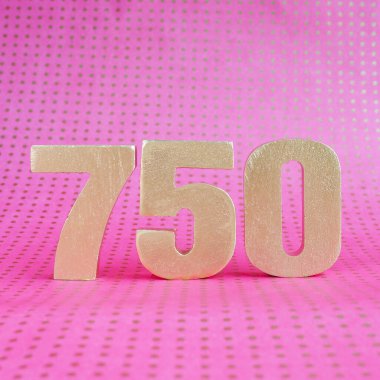 Pembe benekli parlak zemin üzerinde 750 numaralı altın hacim. Boşluğu kopyala