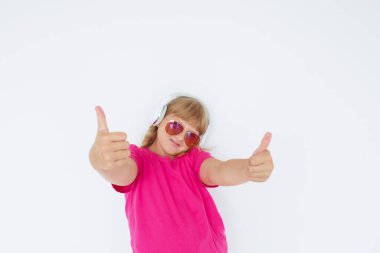 Kulaklıklı, güneş gözlüklü, parlak pembe tişörtlü sarışın genç kız ellerini beyaz bir duvara doğru uzatmıştı.