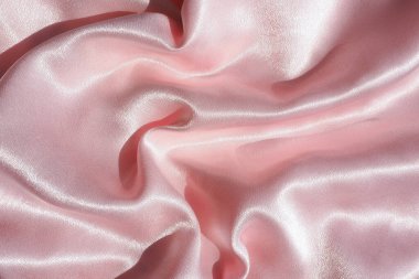 Parlak güneş ışığında buruşmuş saten kumaşın arkaplanı ve dokusu.