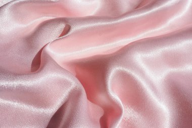 Parlak güneş ışığında buruşmuş saten kumaşın arkaplanı ve dokusu. Boşluğu kopyala