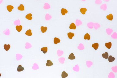 Kaotik yalan konfetisinin soyut arka planı. Pembe ve altın rengi kalp şeklinde..