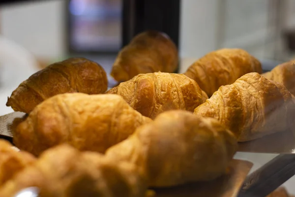 Fresh airy crispy croissants in a shop window — Stock Photo, Image