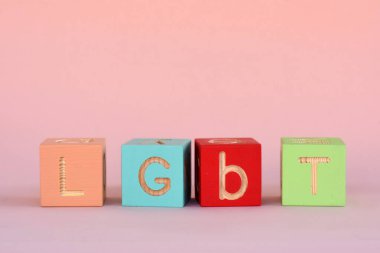 Pembe arkaplandaki renkli LGBT küplerinden bir yazı. Yüksek kalite fotoğraf