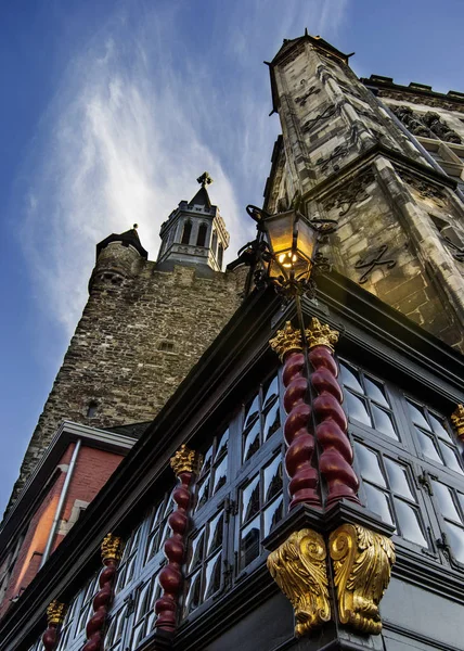 Lantern of an old restaurant in the old town hall of Aachen, Germany with blue sky and a tower