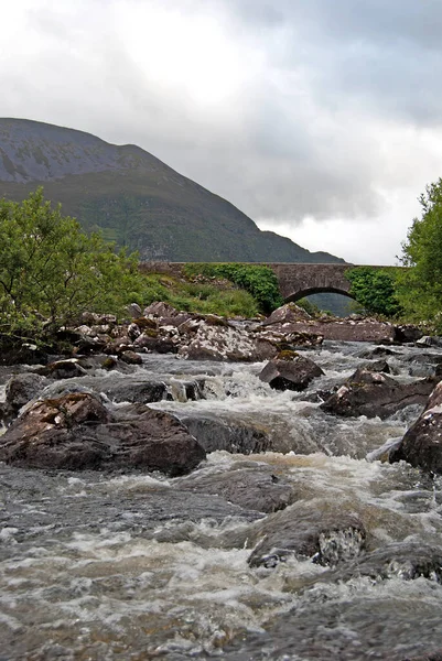 İrlanda 'daki Killarney Ulusal Parkı yakınlarındaki Dunloe Geçidi' nde eski bir taş köprü.