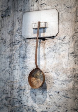 Kaşık bir duvarda asılı bir dükkanda daldırma metal cüruf