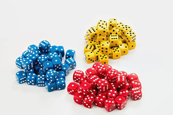 Tři hromady červené, modré a žluté kostky na bílém — Stock fotografie