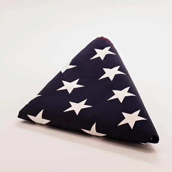 Amerikanische Flagge zu einem perfekten Dreieck mit blauen Sternen gefaltet — Stockfoto