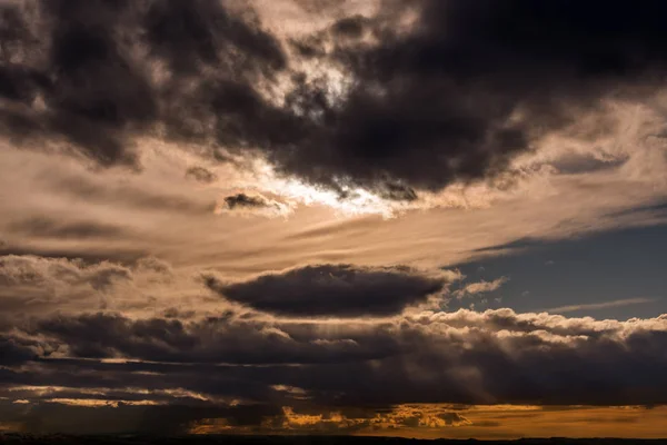 Nubes claras al atardecer con colores cálidos y rayas de sol — Foto de Stock