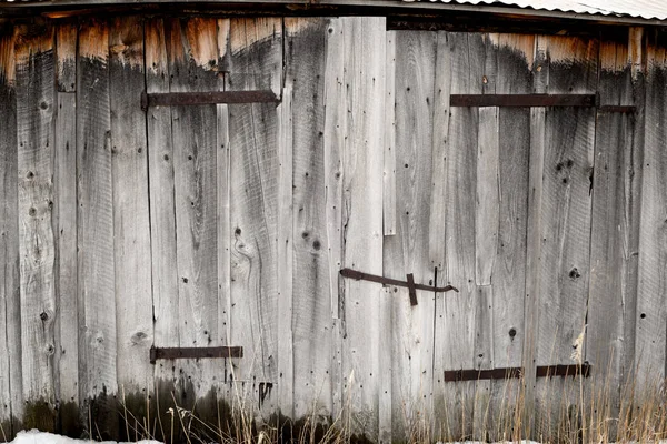 Madera envejecida y bisagras oxidadas en un antiguo granero en una granja —  Fotos de Stock