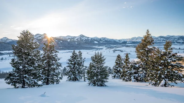 Los últimos rayos de sol de la tarde brillan en un valle de invierno cubierto de s — Foto de Stock