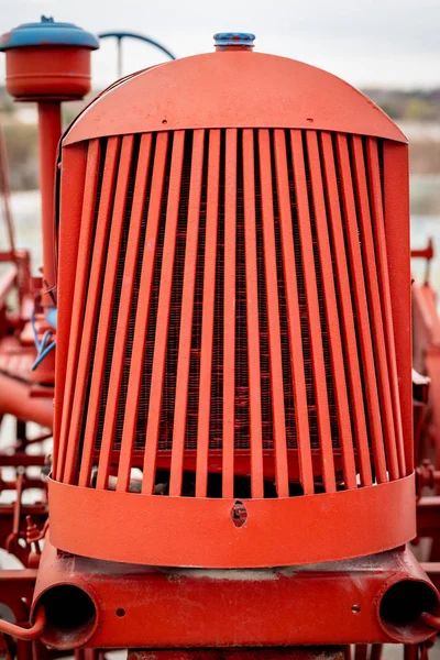 Close up de uma grelha de trator vermelho com linhas de ling que formam um remendo — Fotografia de Stock