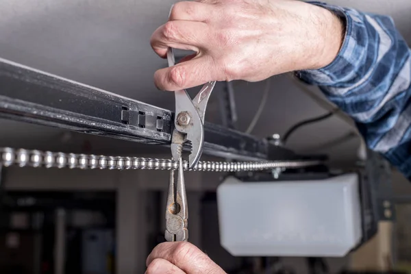 Inicio cadena de apertura de puerta de garaje está siendo reparado por un mecánico — Foto de Stock