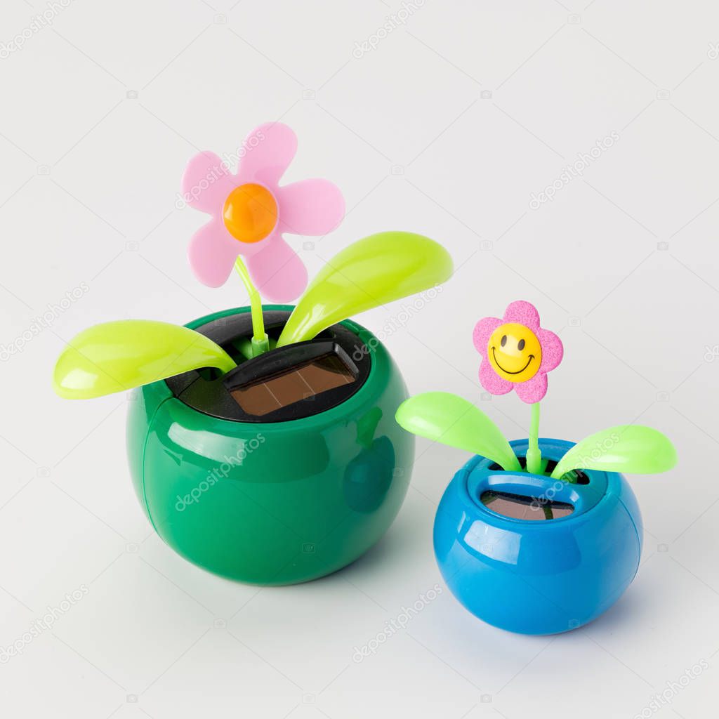 Solar powered toy flowers on a white table top