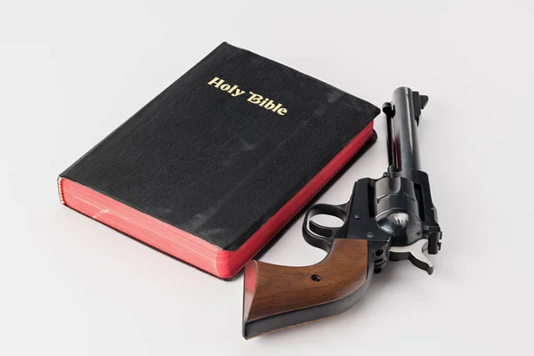 Revolver pistole a holly bible na bílý povrch — Stock fotografie