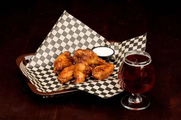 Piliç kanatları sepeti ve yemek için hazır bir bira