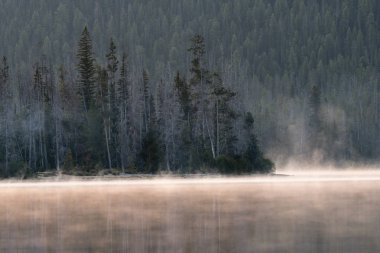 Sis gün doğmadan önce bir dağ Gölü boyunca temizler