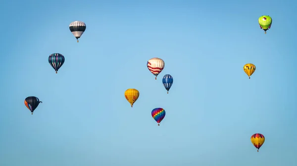 Des ballons flottent dans le ciel en petits groupes au ciel bleu — Photo