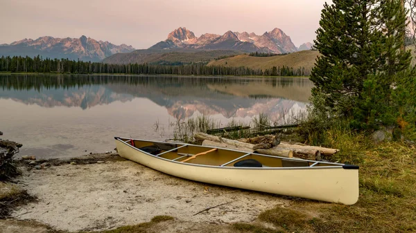 Sawtooth Mountains of Idaho with a canoe parked on the shore of