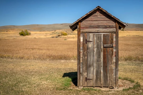 Pequena casa na pradaria feita de madeira na borda de um fie — Fotografia de Stock