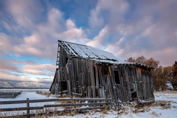 と塗装された雲と冬の素朴な古い納屋 — ストック写真