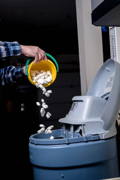 Handyman bir su yumuşatıcı içine tuz taze bir yük döker