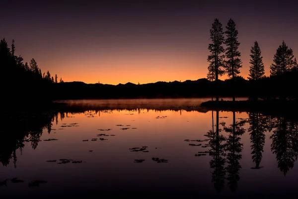 长凳湖锯齿日落与剪影森林反射 — 图库照片