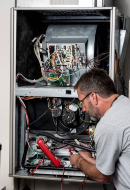 Usta teknisyen volt metre ile bir ev fırını üzerinde çalışıyor