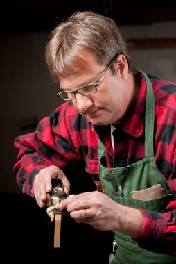 Adam bir tahta parçası üzerinde küçük bir ahşap düzlemile çalışır