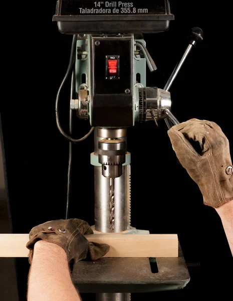 Homem trabalha com uma prensa de broca usando luvas — Fotografia de Stock