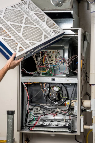 Technician inserts a new furnace filter into the slot — Stock Photo, Image